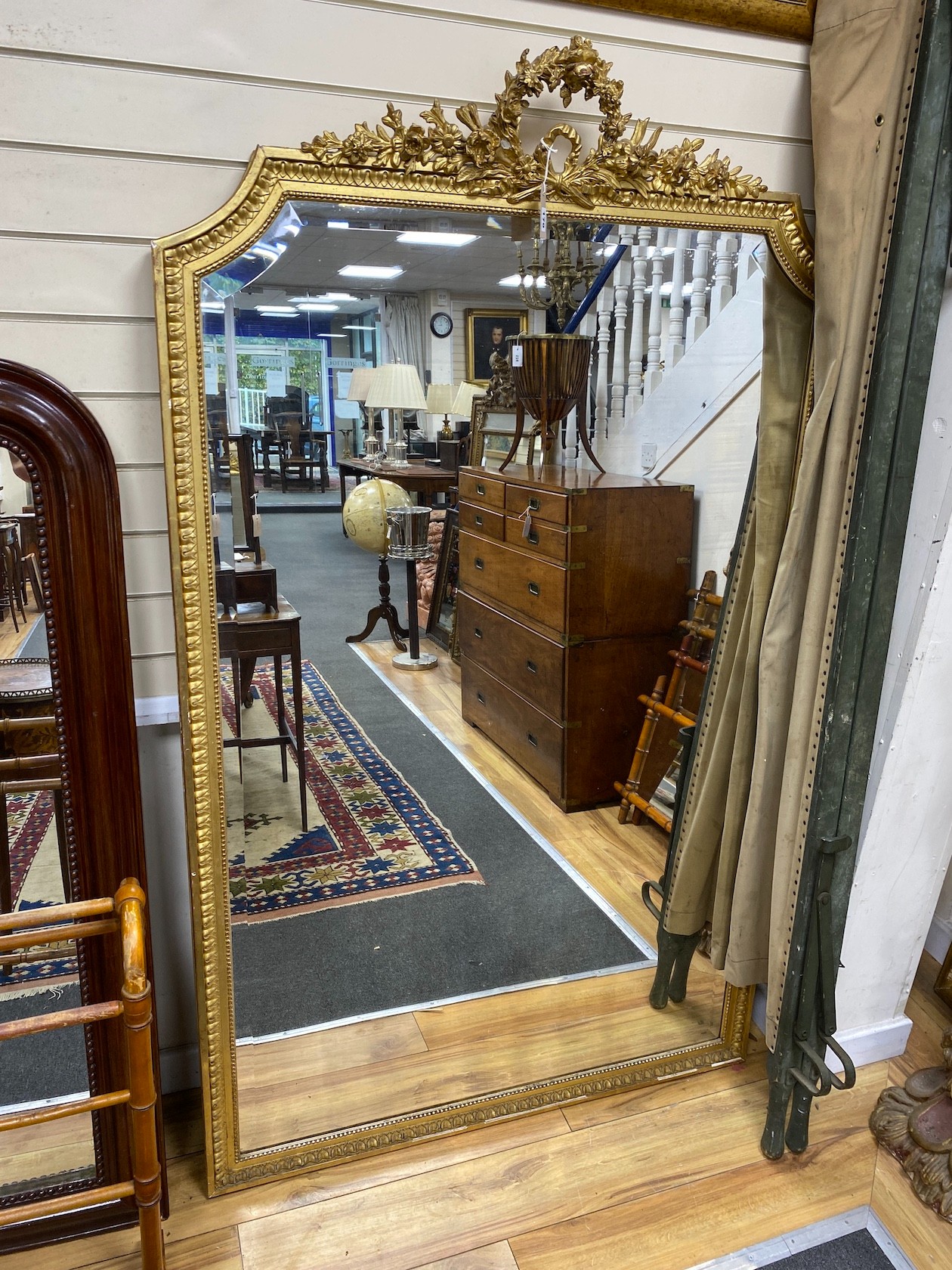 A late 19th century French Louis XVI style giltwood and composition overmantel mirror with floral swag pediment width 110cm, height 185cm.
